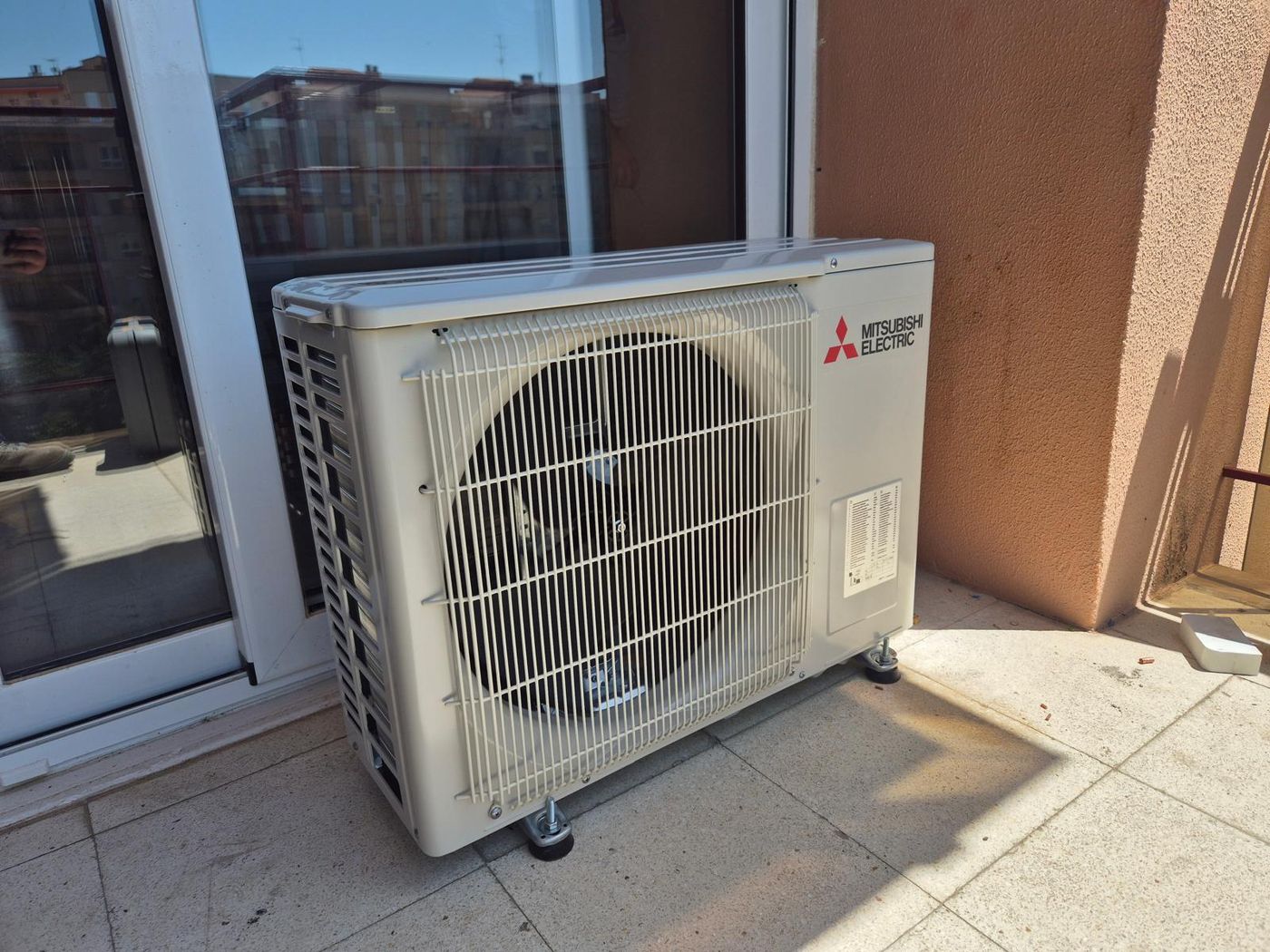 Unidad exterior de aire acondicionado Mitsubishi Electric en una terraza