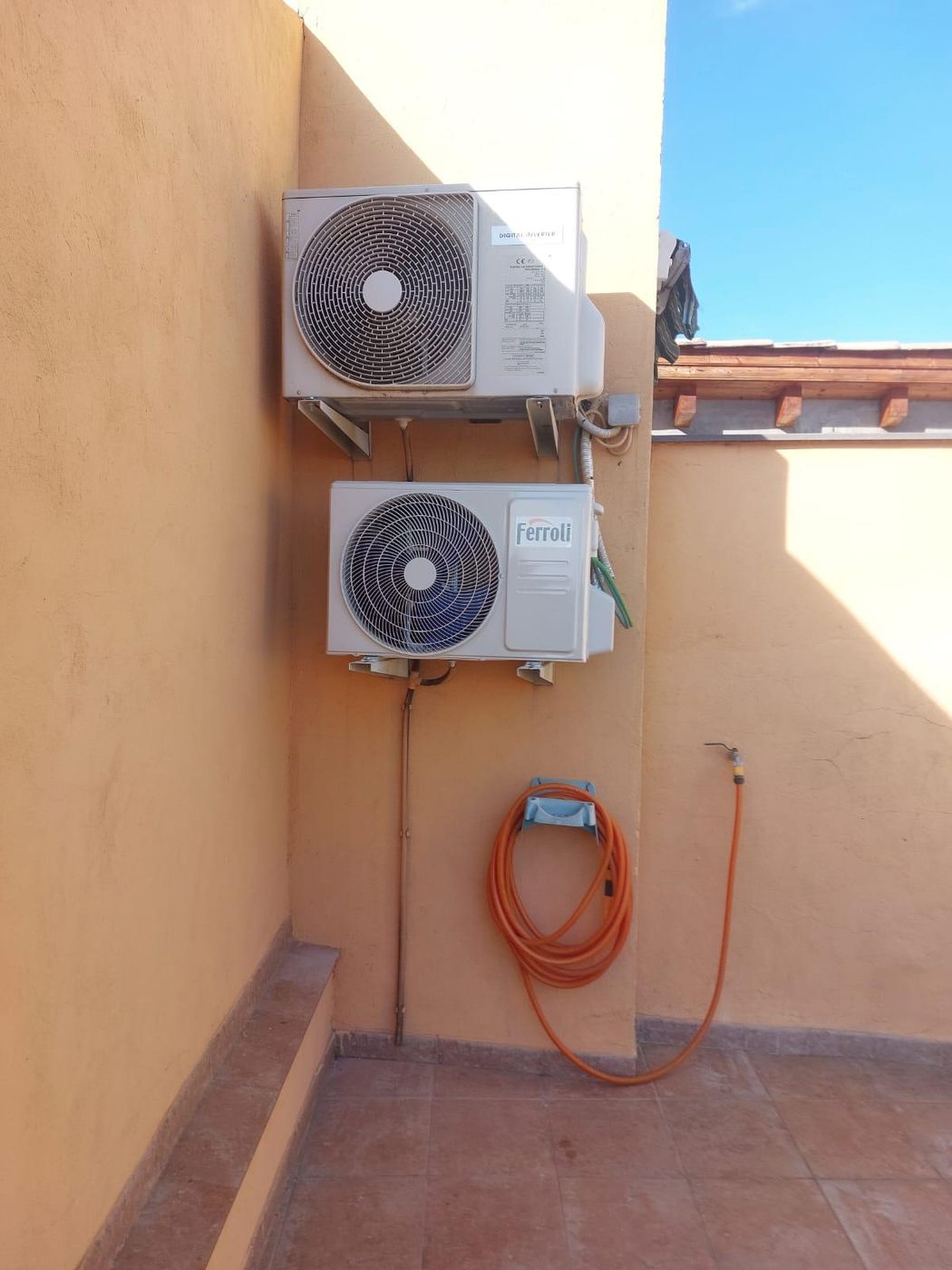 Dos unidades exteriores de aire acondicionado montadas en pared con soportes