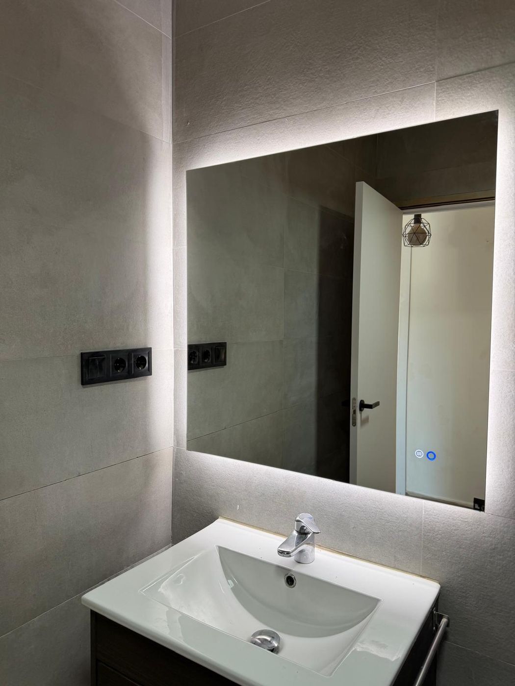Lavabo con espejo retroiluminado LED y enchufes negros